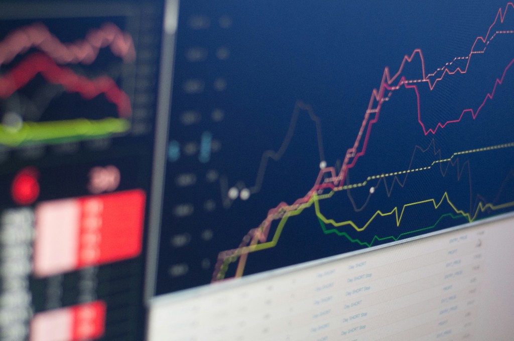 Multi-line analytics dashboard on a monitor with trend charts on a dark screen.